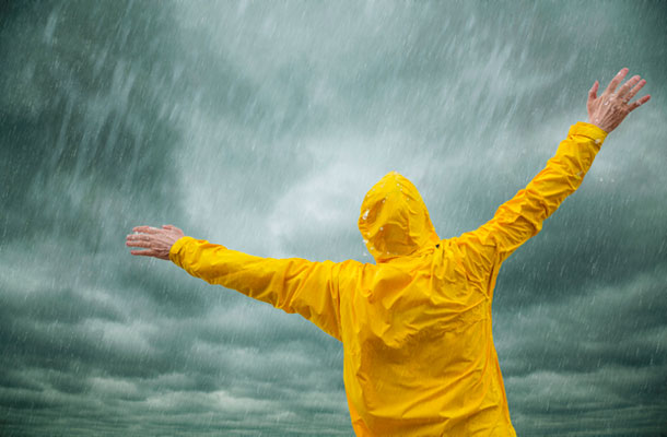 Image of a man stood enjoying the rain.