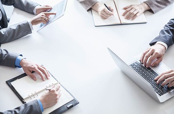 People in a meeting using tablets and laptops.