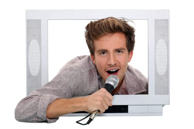 MAn in tv screen with microphone singing.