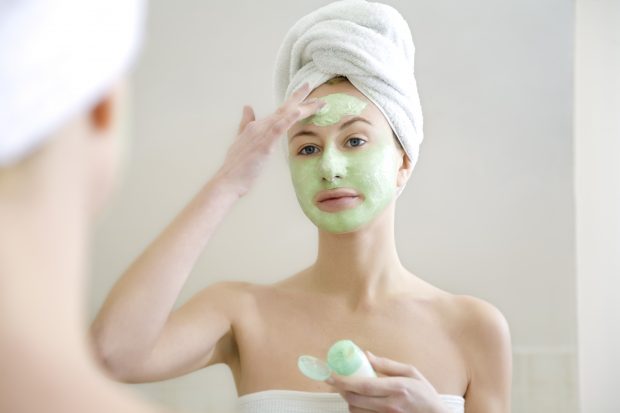 Woman applying face mask.