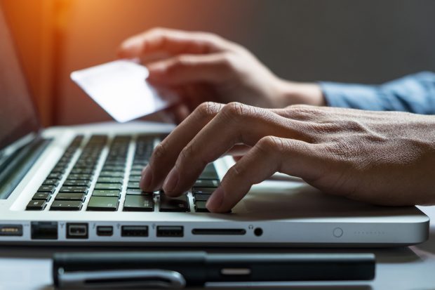 Man holding credit card and paying online