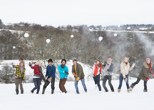 Young teens having a snowball fight.