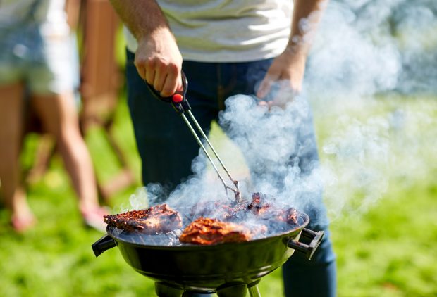 man cooking meat on barbecue grill 