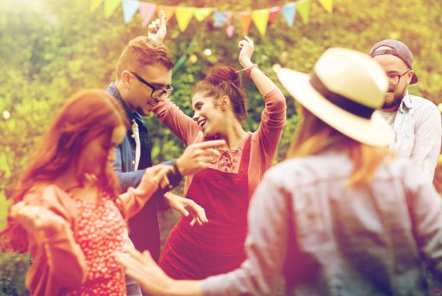 Friends dancing at summer party in garden