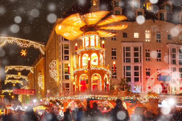 Decorated and illuminated Christmas street with carousel at snowy christmas night in Dresden, Saxony, Germany