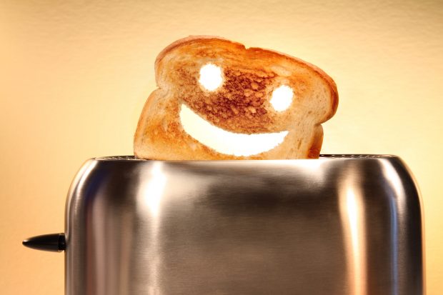 Toast with smiley face cut out, popping out of toaster