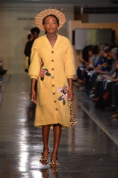 Model on catwalk wearing yellow dress designed by Courtney Mitchell