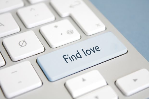 Close up of computer keyboard with greyed out button that reads find love