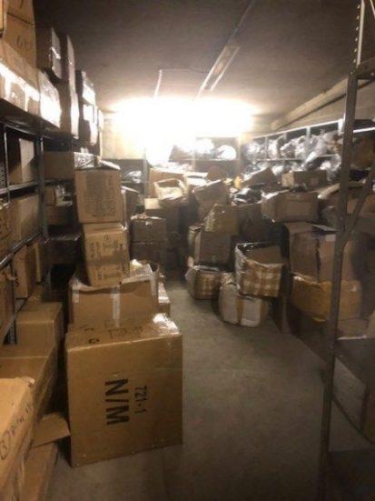 Cardboard boxes of seized counterfeit goods stacked in a store room
