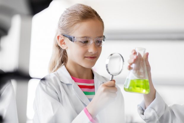 Girl studying test tube at school laboratory