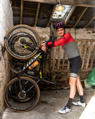 Triathlete Alistair Brownlee standing next to bike held up by Hornit's bike rack CLUG.