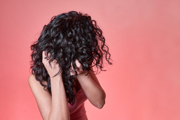 A girl with curly hair scrunching it