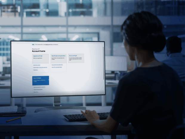An image of a person looking at a computer monitor. It has a gov.uk home page that reads 'account home'.