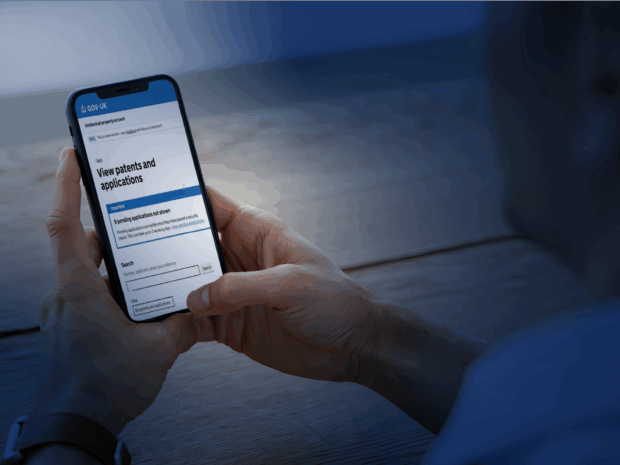 An image of a person looking at a phone screen, showing a gov.uk page.