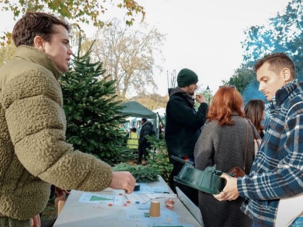 Image shows founder Hugo chatting to customers with a Christmas tree in the background