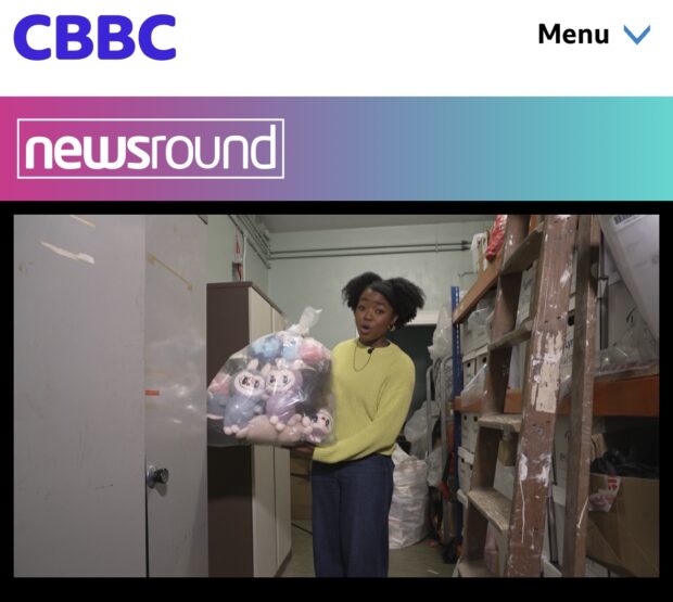 Emma-Louise Amanshia (BBC Newsround presenter) holding a bad of fake toys whist explaining the dangers.
