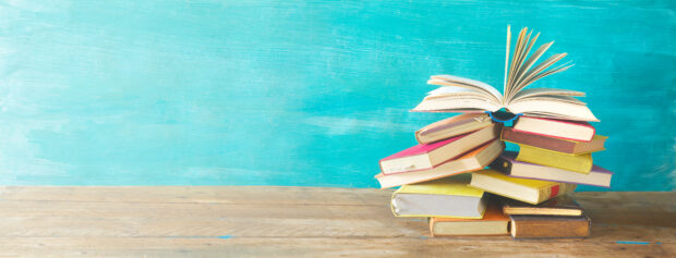 Opened Book on a pile of old books, panorma, good copy space