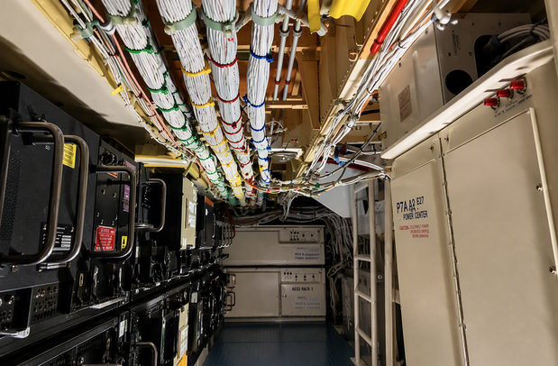 Avionics bay on a Boeing 747 with cabling bundles tied across the ceiling